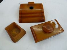 An Art Deco Carvacraft amber resin inkwell, blotter and desk tidy (3)