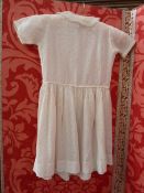 Child's dress in coral-coloured silk and another child's dress with spotted decoration in yellow,