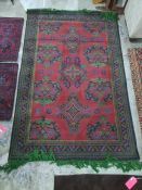 Eastern, possibly Turkish, red ground rug with repeating motifs, in red, green, blue design and