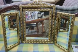 20th century three-part folding dressing table mirror, the gilt decorated frame surmounted by ribbon