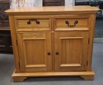 Modern oak cabinet, the rectangular top with canted corners, two drawers, two cupboard doors,