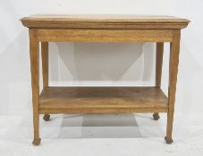 Light oak two-tier side table, circa 1900, the rectangular top with moulded edge, on square