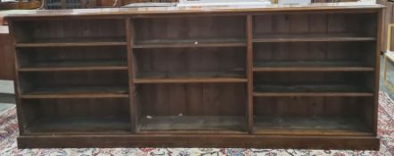 Large mahogany three-section open bookcase raised on plinth base, 289cm x 112cm