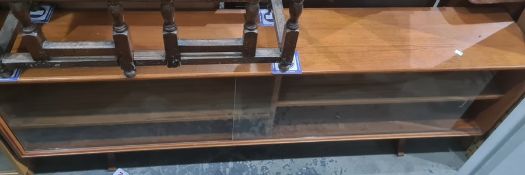 Mid century teak low bookcase, the rectangular top above glass sliding doors enclosing shelves, on