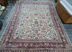 Cream ground Eastern-style rug with allover foliate design, red ground and stepped border, 400cm x