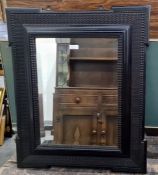 19th century ebonised wall mirror with wavy moulded border, central rectangular bevelled mirror
