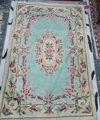 Rug with turquoise ground, the central medallion decorated with flowers, on a single marching