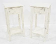 Pair of white painted bedside tables with single drawers and united undertiers, on turned supports