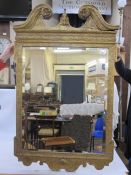 George II style gilt wall mirror with swan-neck pediment in gilt carved wood with foliate, scroll