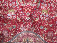 Kashmir 'Tree of Life' red ground carpet, with various birds and animals amongst the tree, stepped