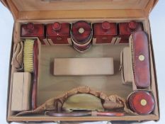 Circa 1930's leather vanity case opening to a leather interior, enclosing red lacquer and inlaid