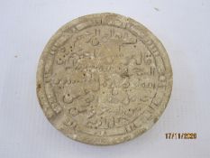 Archaeological find, a small carved stone roundel, the centre with Arabic script within a double