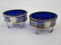 A pair of Victorian silver salts with blue glass liners, oval shaped, pierced decoration, with