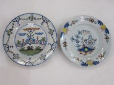 English delft plate, floral decorated and a delft plate decorated with zigzag fence in a garden,