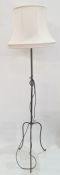 20th century wrought iron standard lamp on three cabriole supports, cream shade