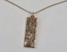 9ct gold pierced pendant, rectangular, scroll decorated on fine 18ct gold chain with engraved