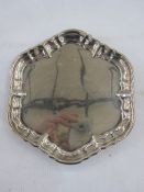 Edward VII silver waiter, hexagonal with raised ogee border, on three scroll feet, London 1910, 15cm