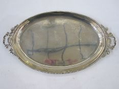 A late 19th/ early 20th century silver two-handled oval tray, beaded rim, scroll shaped handles,