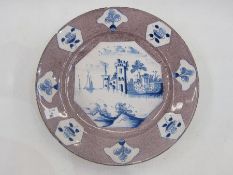18th century delft plate with underglaze blue waterside decoration on a powder manganese ground,