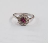 Platinum, ruby and diamond cluster ring set central circular ruby surrounded by nine diamonds,