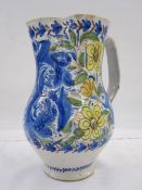 Italian faience jug decorated with scrolling flowers in a blue, green, yellow and orange palette,