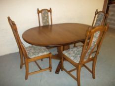 AN ERCOL DINING SET WITH FOUR CHAIRS AND EXTENDING TABLE