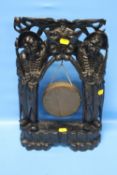 AN ANTIQUE CHINESE GONG, MOUNTED IN CARVED WOOD STAND WITH WHITE METAL WIRE INLAY