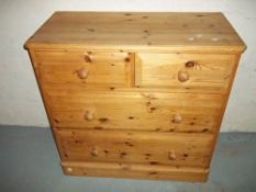 A SOLID PINE TWO OVER TWO CHEST OF DRAWERS