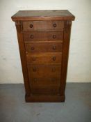AN OAK NARROW CHEST OF DRAWERS