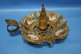 A GILT METAL CANDLE HOLDER WITH CAMEO INSETS AND A CANDLE SNUFFER