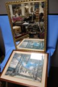 A GILT FRAMED MIRROR, 98 X 67 CM TOGETHER WITH A FRAMED AND GLAZED PRINT OF A STREET SCENE