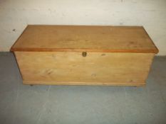 A WOODEN STORAGE BOX CHEST ON WHEELS