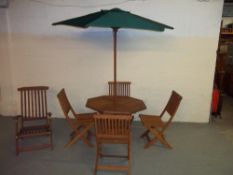 A WOODEN FOLD AWAY GARDEN TABLE SET WITH FOUR CHAIRS, A LOUNGER AND A PARASOL