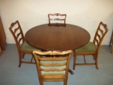A YEW SINGLE PEDESTAL DINING TABLE AND FOUR SOLID STURDY CHAIRS (MISSING EXTENSION LEAF), G.T.