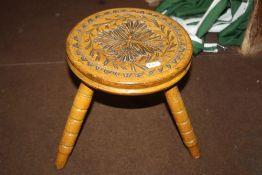 A CARVED WOODEN STOOL