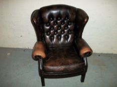A BROWN LEATHER WING BACK CHAIR