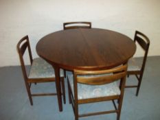 A ROSEWOOD EXTENDING DINING TABLE AND FOUR MATCHED CHAIRS BY McINTOSH