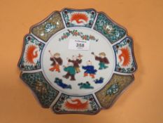 A SHAPED ORIENTAL DISH WITH FIGURATIVE DETAIL AND CHARACTER MARKINGS TO BASE