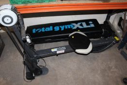 A TOTAL GYM XLI WORKOUT BENCH AND A ROWING MACHINE