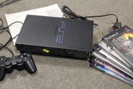 A PS2 CONSOLE AND GAMES CONTROLLER