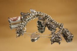 A HEAVY HALLMARKED SILVER VINTAGE CHARM BRACELET