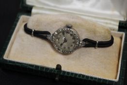 A LADIES VINTAGE PLATINUM AND DIAMOND SET WATCH - EACH BRILLIANT CUT DIAMOND APPROX 0.02 CARATS -