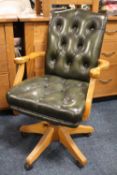 A MODERN GREEN LEATHER OFFICE SWIVEL ARMCHAIR