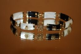 AN ORIENTAL 9CT GOLD MOTHER OF PEARL & BLACK ONYX STYLE BRACELET STAMPED 375