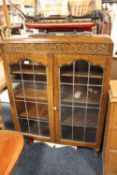 A VINTAGE OAK GLAZED BOOKCASE WITH CARVED DETAIL H-117 CM W-87 CM