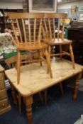 A HONEY PINE KITCHEN TABLE WITH FOUR TRADITIONAL STYLE CHAIRS