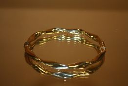 A 9CT GOLD TWIST STYLE BANGLE STAMPED 375