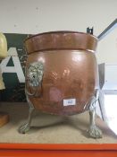 A COPPER TWIN HANDLED COAL BUCKET RAISED ON BRASS FEET