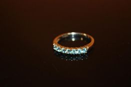 A LADIES 9 CARAT WHITE GOLD DRESS RING SET WITH SEVEN BLUE STONES - SIZE N - WEIGHT 2.2 GRAMS