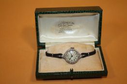 A LADIES VINTAGE PLATINUM AND DIAMOND SET WATCH - EACH BRILLIANT CUT DIAMOND APPROX 0.02 CARATS -